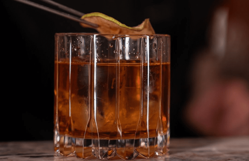 Negroni with orange on top in a classic whisky glass