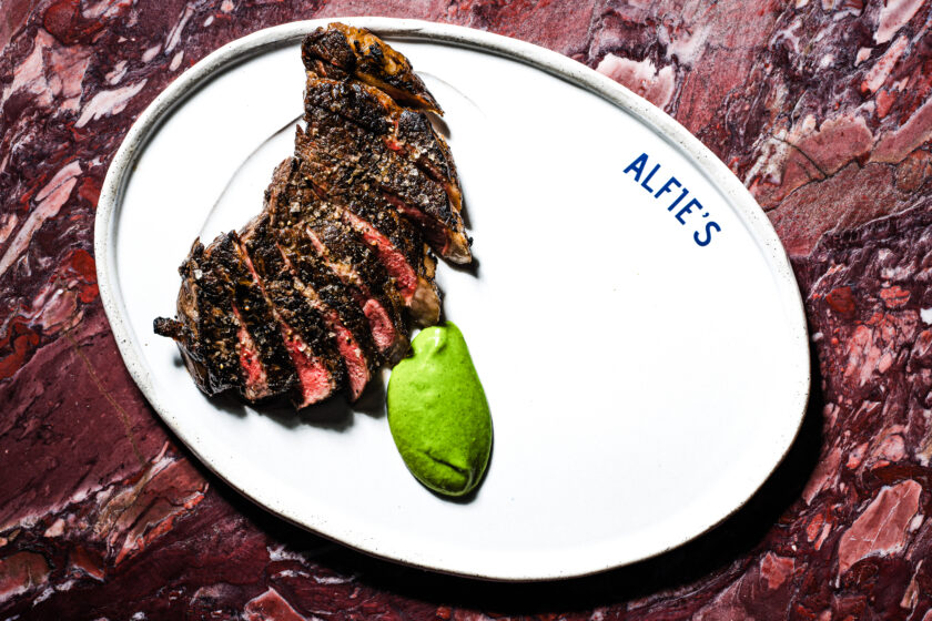 Alfie's steakhouse in Sydney with a medium-rare sirloin on branded plate paired with horseradish.