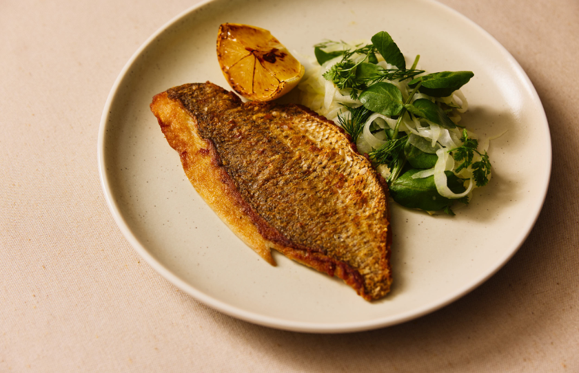 Fish, lemon and vegetables on a white plate