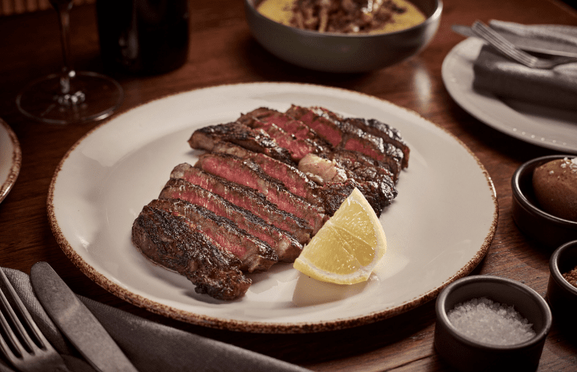 Steak on plate with lemon garnish, RAFI North Sydney