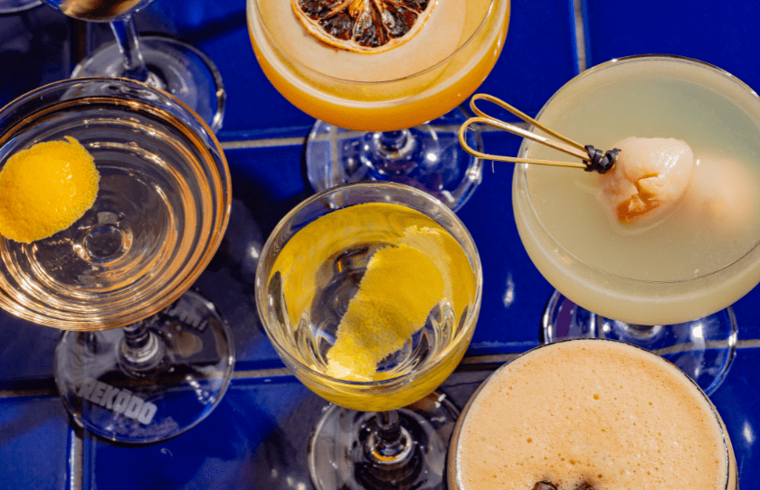 Martinis on table with lemon and lychee at Rekodo Martini house event. Blue table and mini martini glasses 