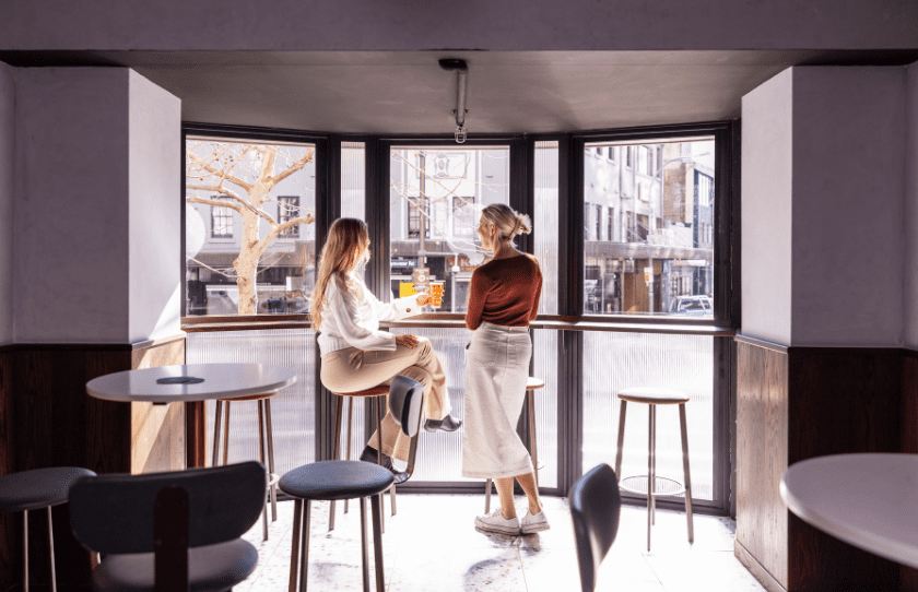 Long windows at Penny's Hotel with two ladies enjoying a drink in front of the window in Potts Point